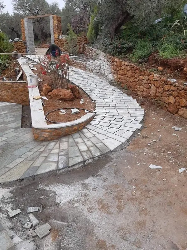 Curved grey μονοπάτι πλακών ochre retaining planter — PelionStones.gr