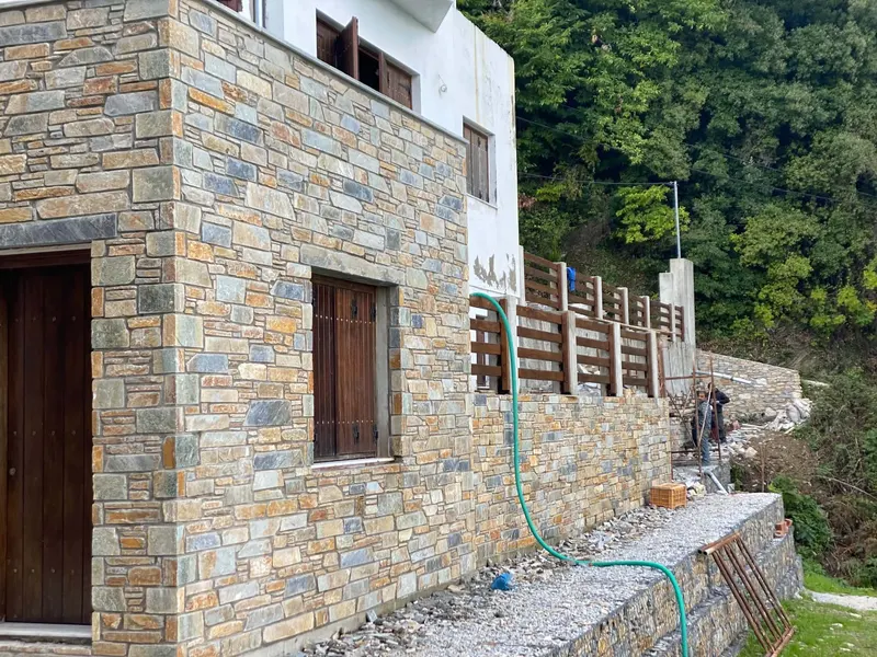 Hillside villa ώχρα-γκρι επένδυση τοίχου ξύλινα παντζούρια — PelionStones.gr