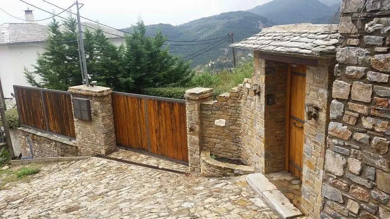Ochre grey pillars ξύλινη πόρτα στέγη σχιστόλιθου entry — PelionStones.gr