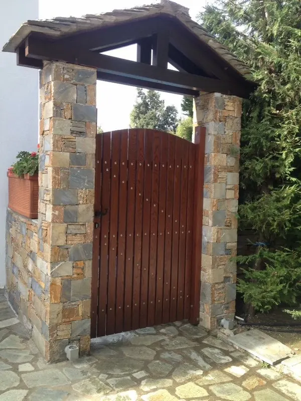 Ochre rust pillars gabled στέγη σχιστόλιθου μονοπάτι πλακών — PelionStones.gr